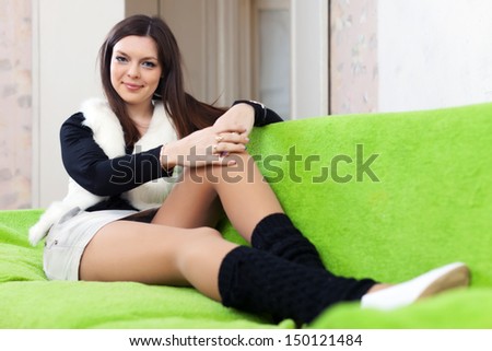 Portrait of brunette woman in leg warmers at home interior