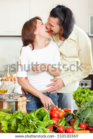 Man and woman with vegetables in kitchen at home