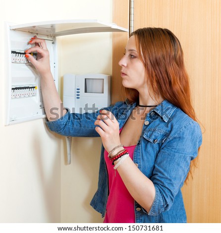 Sad cute woman near power control panel  at home