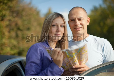 tourist couple looking at the map on the road. Focus on woman