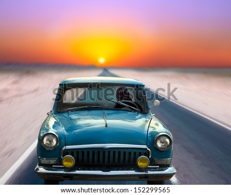 Old Car Driving On The Road At Dusk