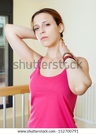 young woman holding her neck because ill at home