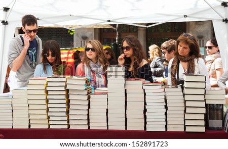 BARCELONA, CATALONIA - APRIL 23: People looking books  in Saint George day in April 23, 2013 in Barcelona, Catalonia. Books and red roses is traditionally gifts of festival