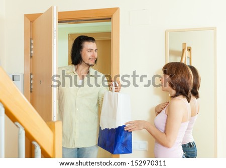 A good man gives gift to woman at home