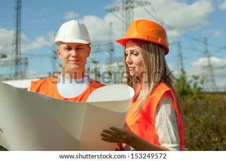 two workers wearing protective helmet works at electrical power station