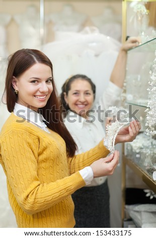 Two women  chooses bridal accessories in wedding boutique