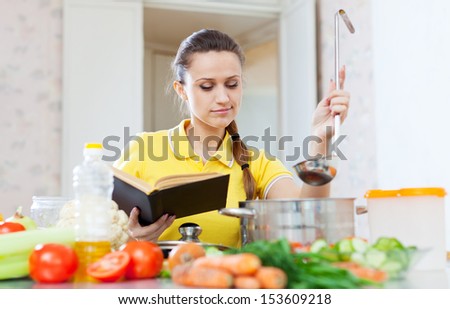woman cooking   food with book at  kitchen