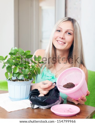 Girl works with  flower pots at her home