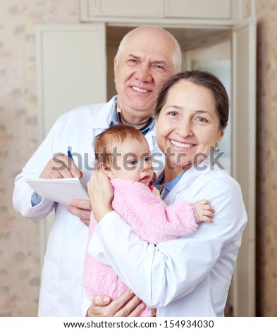 friendly doctors with little baby in medical clinic