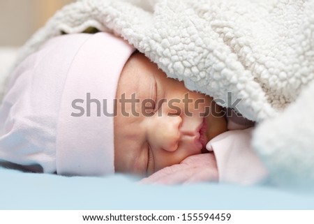 newborn baby sleeps under blanket
