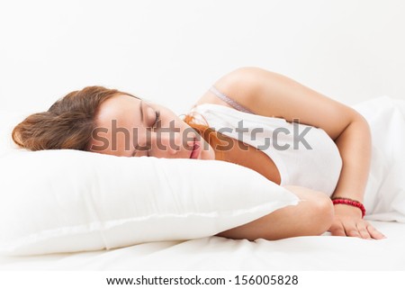 Nice red-haired woman sleeping on white pillow in bed