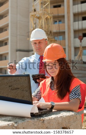 White-collar workers wearing protective helmet works on the building site