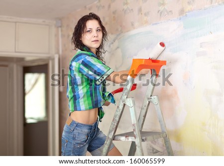 Woman makes repairs in the apartment