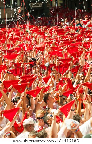 PAMPLONA, SPAIN - JULY 6: Cheering people with red shawl in square in July 6, 2013 in Pamplona, Spain. Opening of San Fermin Festival