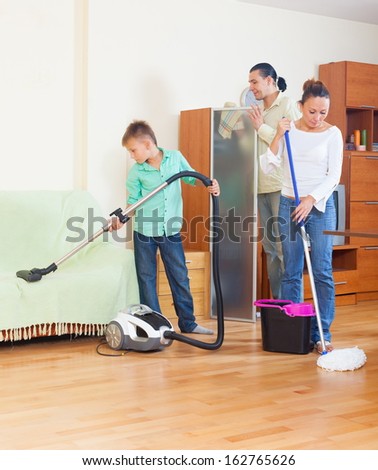 Middle-aged couple with teenage boy doing house cleaning
