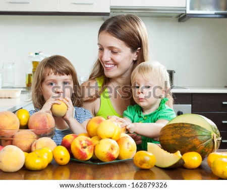Happy family together with melon and peaches over dining table at home interior