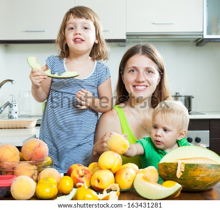 Happy family eating melon and other fruits at home