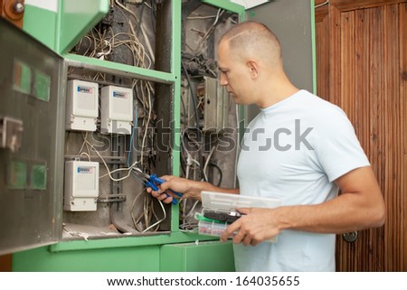 electrician working with electric box at house