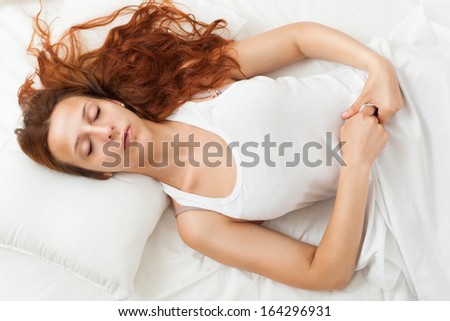 beauty bed-haired girl sleeping on white pillow in bed at home
