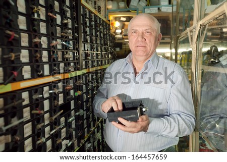 mature man chooses fasteners in  auto parts store