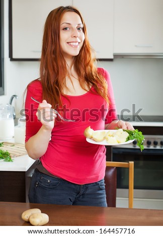 ordinary woman eating jacket potatoes at home interior