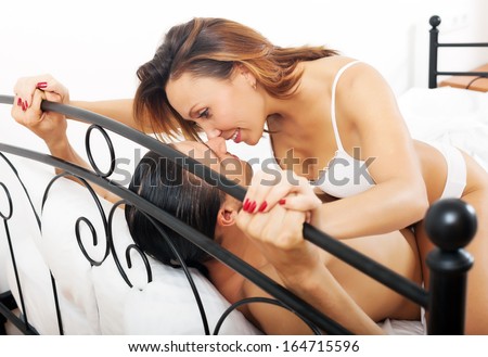 Pretty woman kissing  man in chest in bed