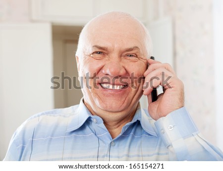 Portrait of joyful handsome senior man speaking by mobile