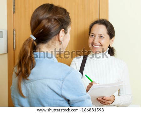 woman filling questionnaire for employee at door