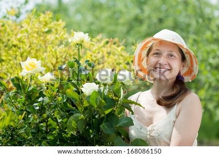 Female gardener in rose plant at garden