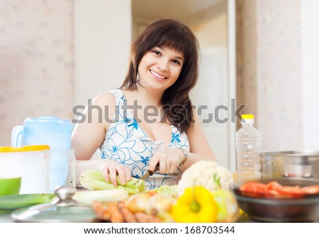 Positive pretty woman cutting the celery for salad