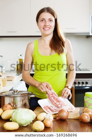 woman with lamb meat in her kitchen