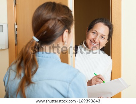 woman questionnaire for  mature social worker or employee of the company at door