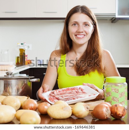 Young woman  cooking with lamb meat