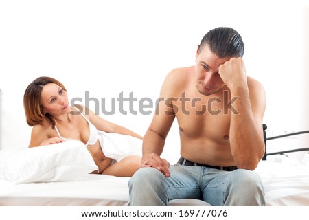 Woman consoling the depressed husband in bedroom at home