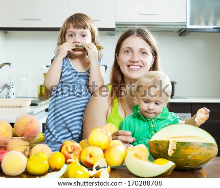 Happy family together with melon over dining table at home