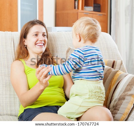 Portrait of happy mom with child on sofa