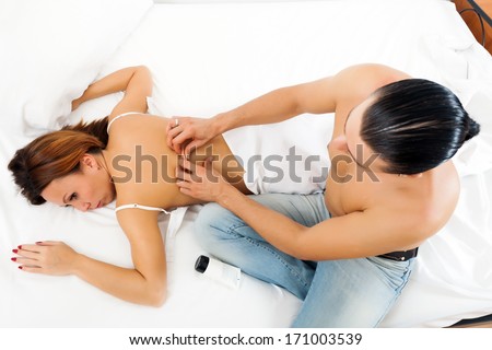 Man massaging the back of his woman in bed