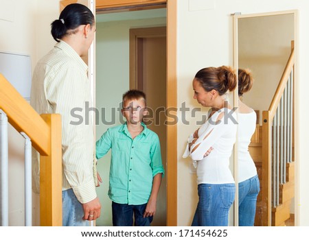 Parents meeting with scold of teenage son in doorway at home