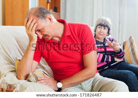 Family quarrel. Sad mature man listening to angry wife at home