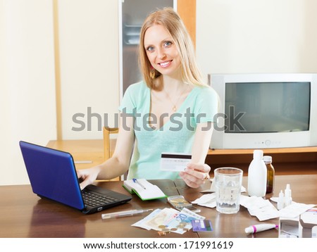 Girl buying drugs online with laptop and credit card at home