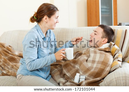 Happy Woman  giving drugs to diseased man at home