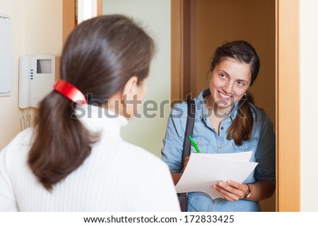 woman questionnaire for smiling social worker or employee at door