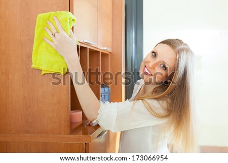 Blonde  woman cleaning furniture at home