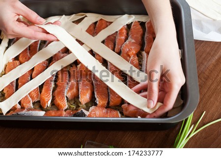 Close up of cooking fish pie with raw salmon in sheet pan