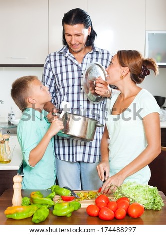 Happy family cooking with fresh vegetables at home kitchen