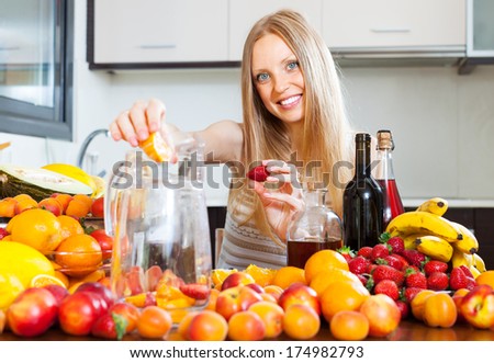 Happy woman making fruits beverages with wine