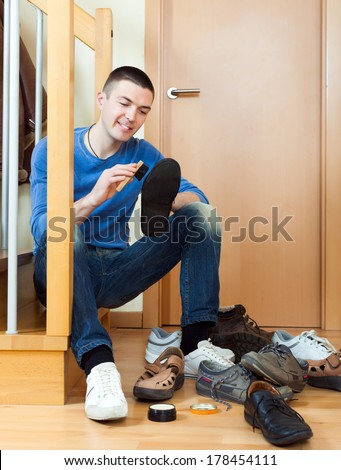 Happy man  cleaning shoes on stairs