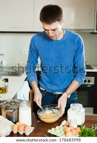 man cooking omelet with flour in the kitchen