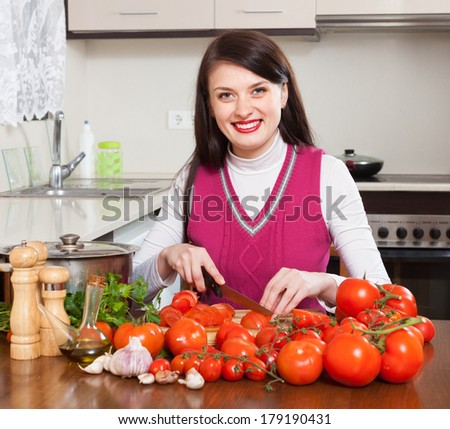 brunette woman slicing tomatoes in home kitchen