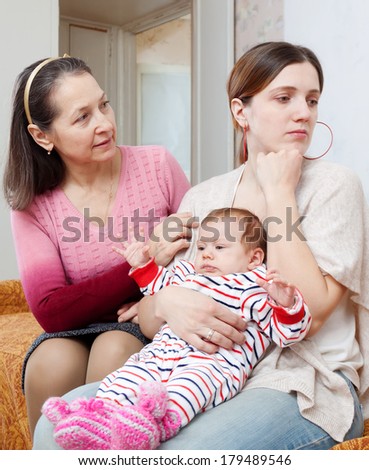 Female family problems. Mature woman comforts crying adult daughter with baby at home